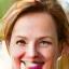 Portrait of Sarah Chen, a smiling woman in her late 40s